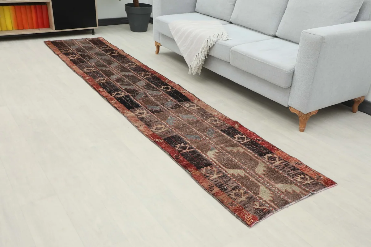 Angled view of the brown, rust, and black geometric runner rug in a modern living space.