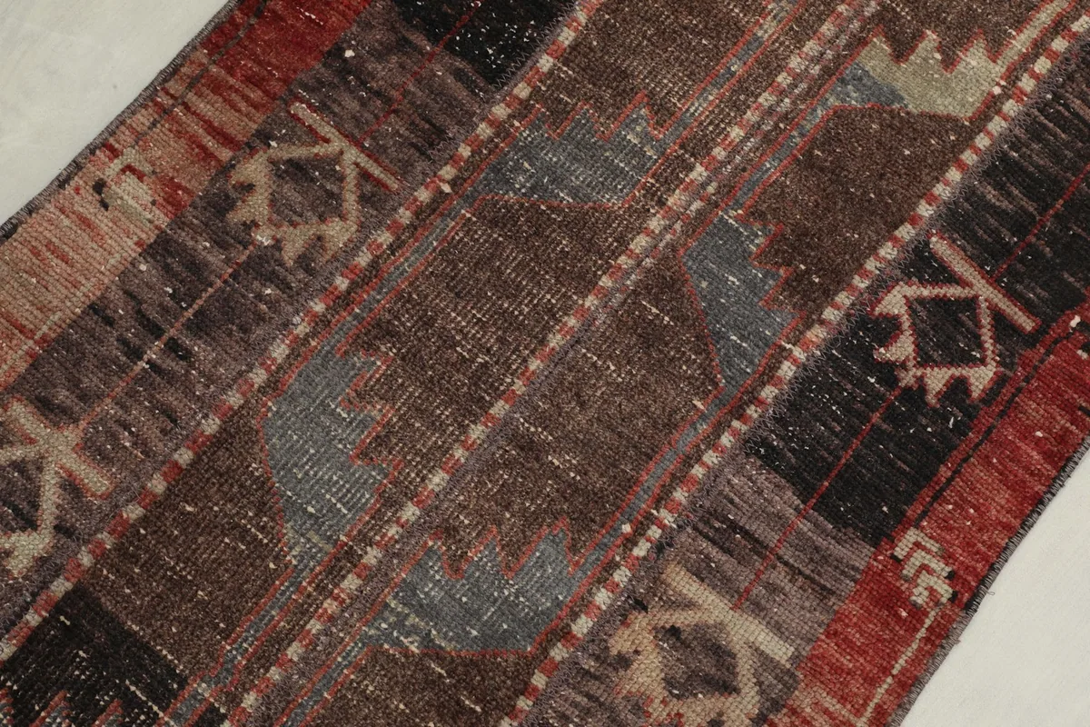 Detailed view of the hand-knotted wool pile, showing the distinct color variations and subtle wear.