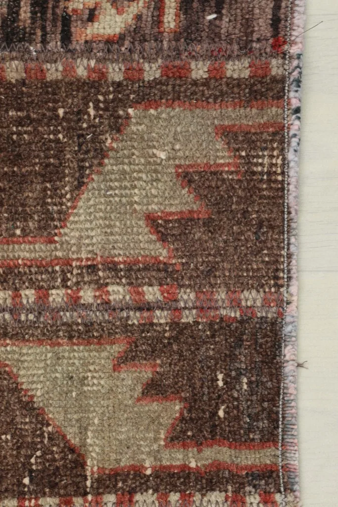 Close-up of the rug's edge, showing the finished side and the texture of the wool pile.