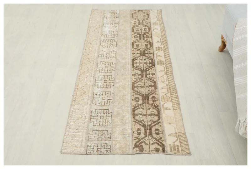 Full top view of the tan and brown striped geometric vintage Anatolian area rug on a white floor.