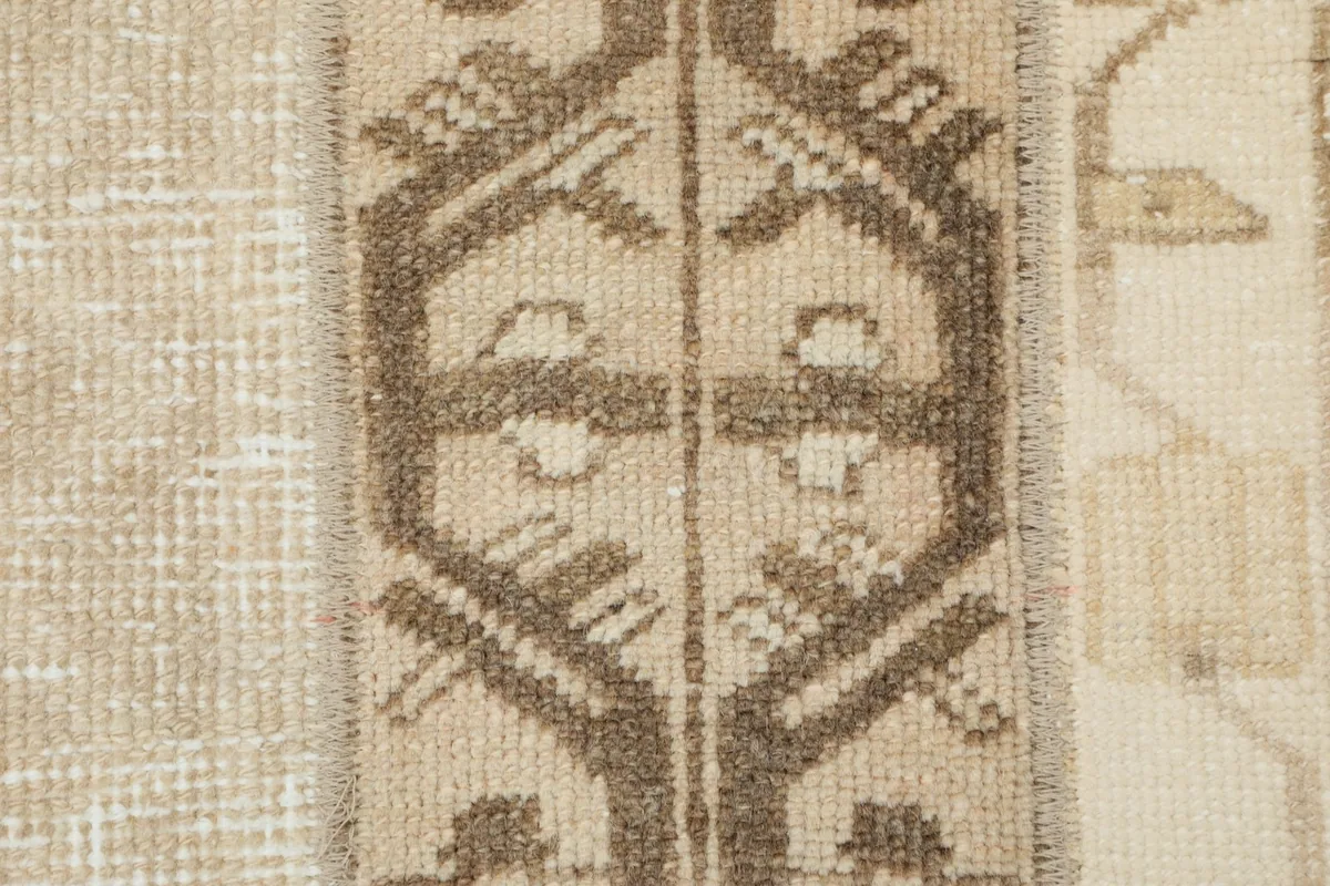 Detailed shot of a central brown geometric motif within one of the rug's vertical stripes.