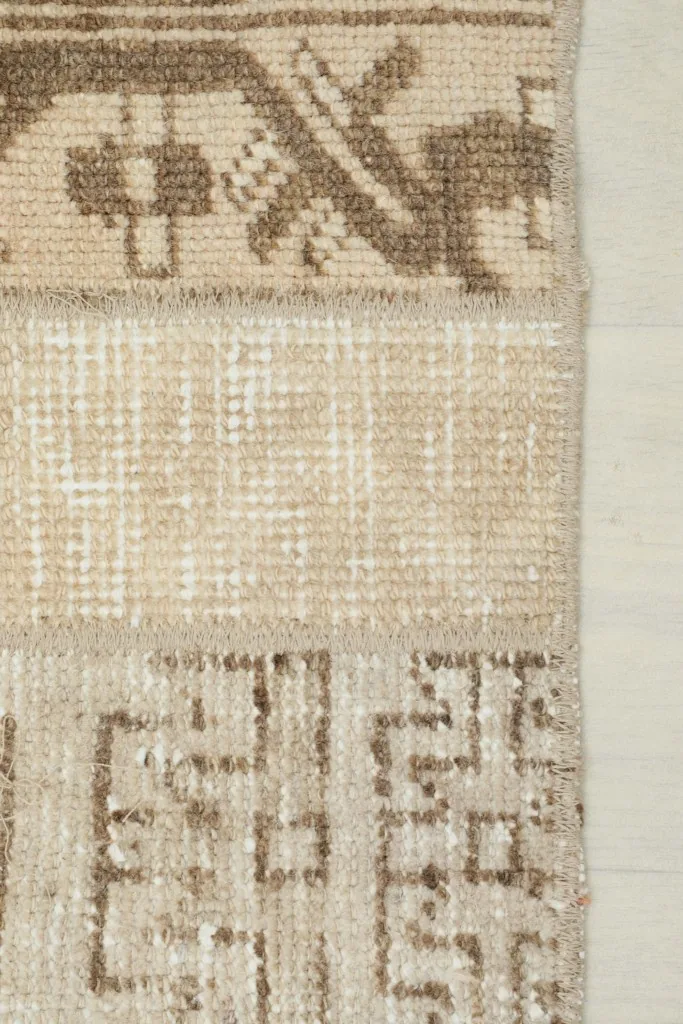 Close view of the low wool pile and hand-knotted texture of the vintage area rug.