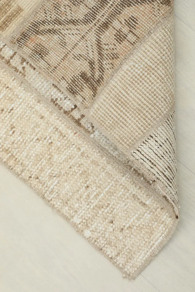 Underside view of the rug showing the cotton foundation and the reverse of the hand-knotted construction.