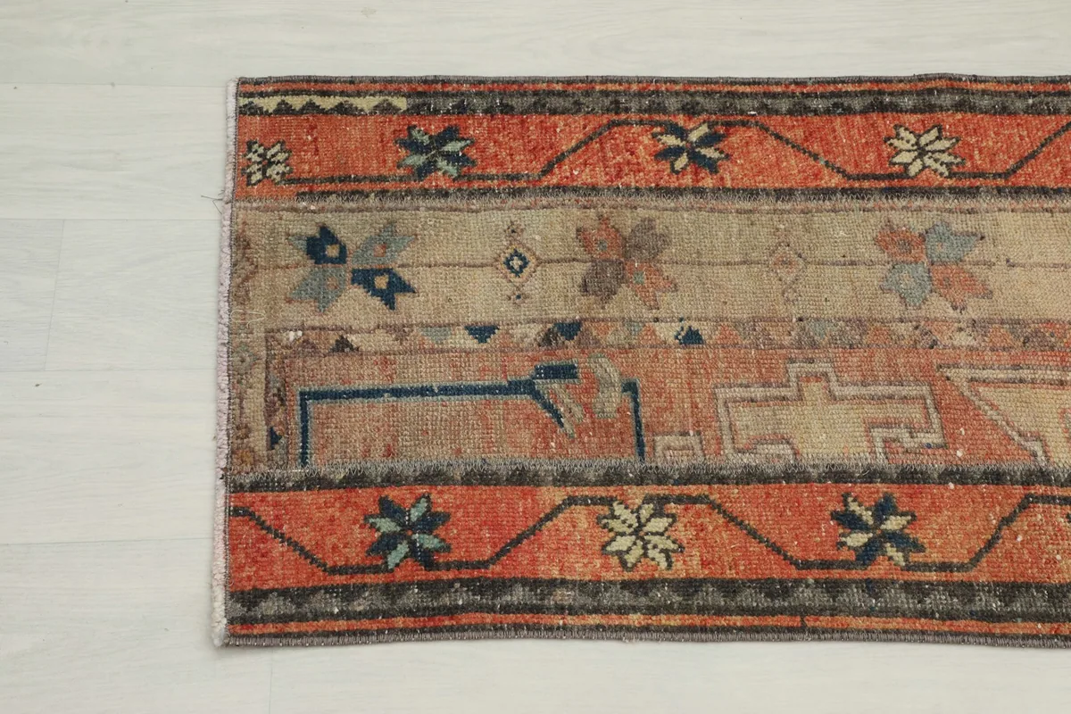 Close-up of the rug's end, showing the border design and the subtle color variations in the field.