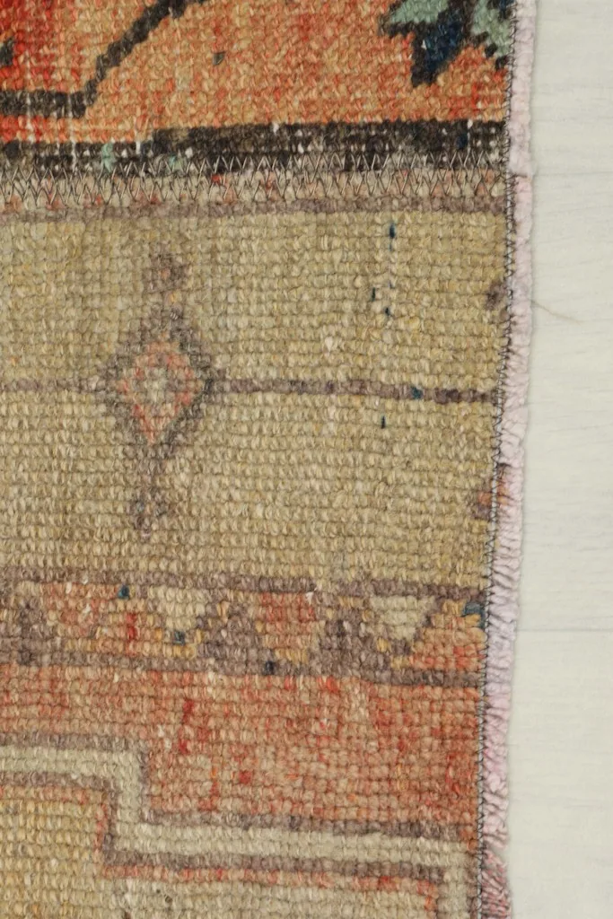 Detail of the rug's edge, showing the tightly woven cotton foundation and short, integrated fringe.