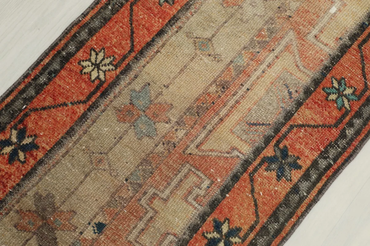 Overhead detailed shot highlighting the geometric motifs and texture of the vintage rug.