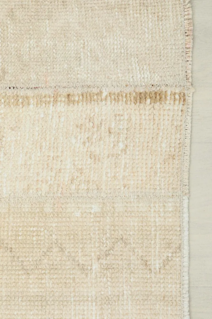View of the back of the runner rug, showcasing the cotton foundation and the tightly woven knots.