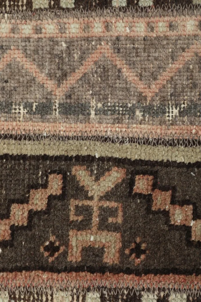 Detailed shot of the rug's texture and specific tribal symbols in brown and beige