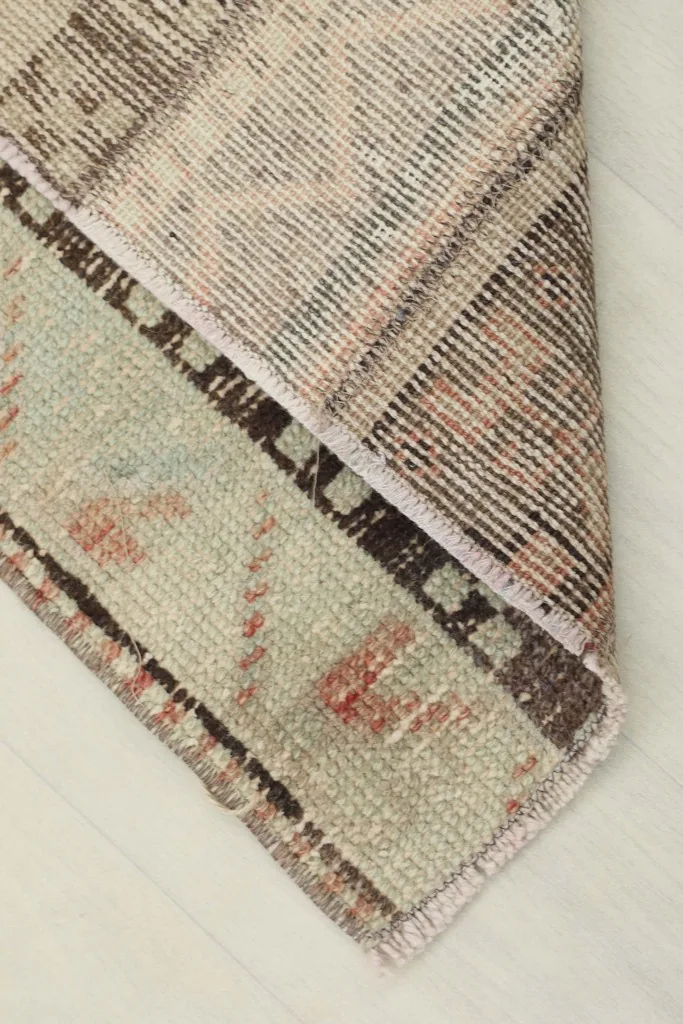 View of the rug's underside, revealing the cotton foundation and knotting structure