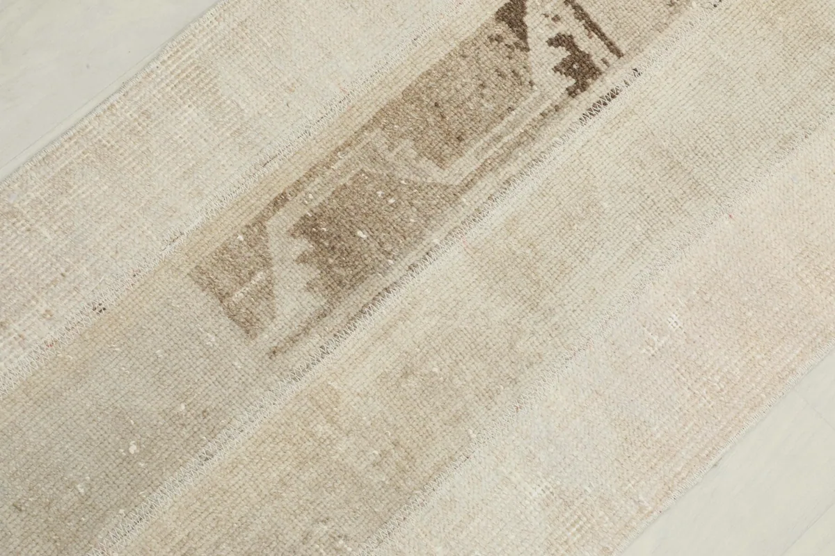 Detailed view of the central brown and tan distressed section within the runner's patchwork