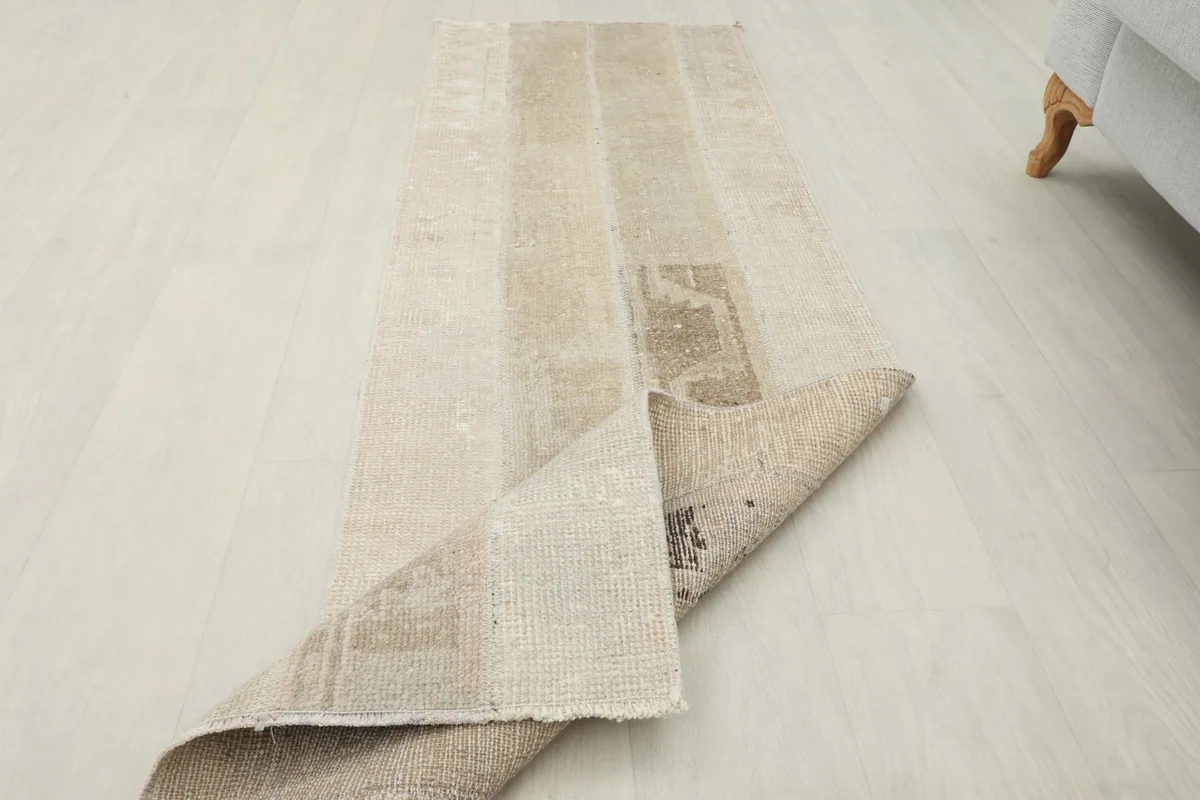 Runner rug partially folded, displaying both the top surface and the sturdy cotton foundation