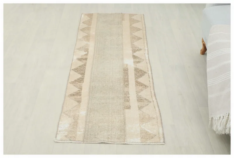 Full top view of the 2x5 beige and tan vintage Anatolian runner rug on a white background.