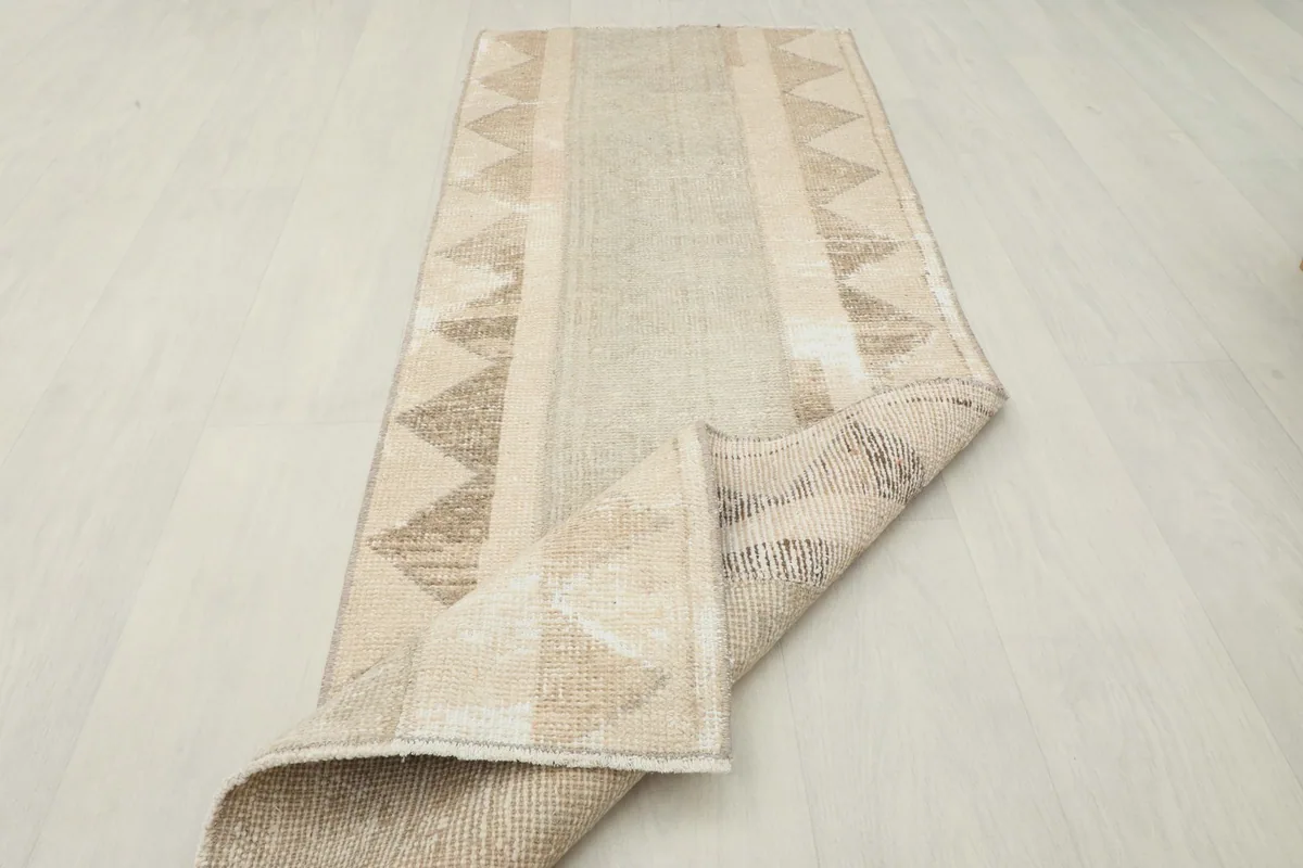 The runner rug partially folded, demonstrating its flexibility and the thickness of the wool pile.