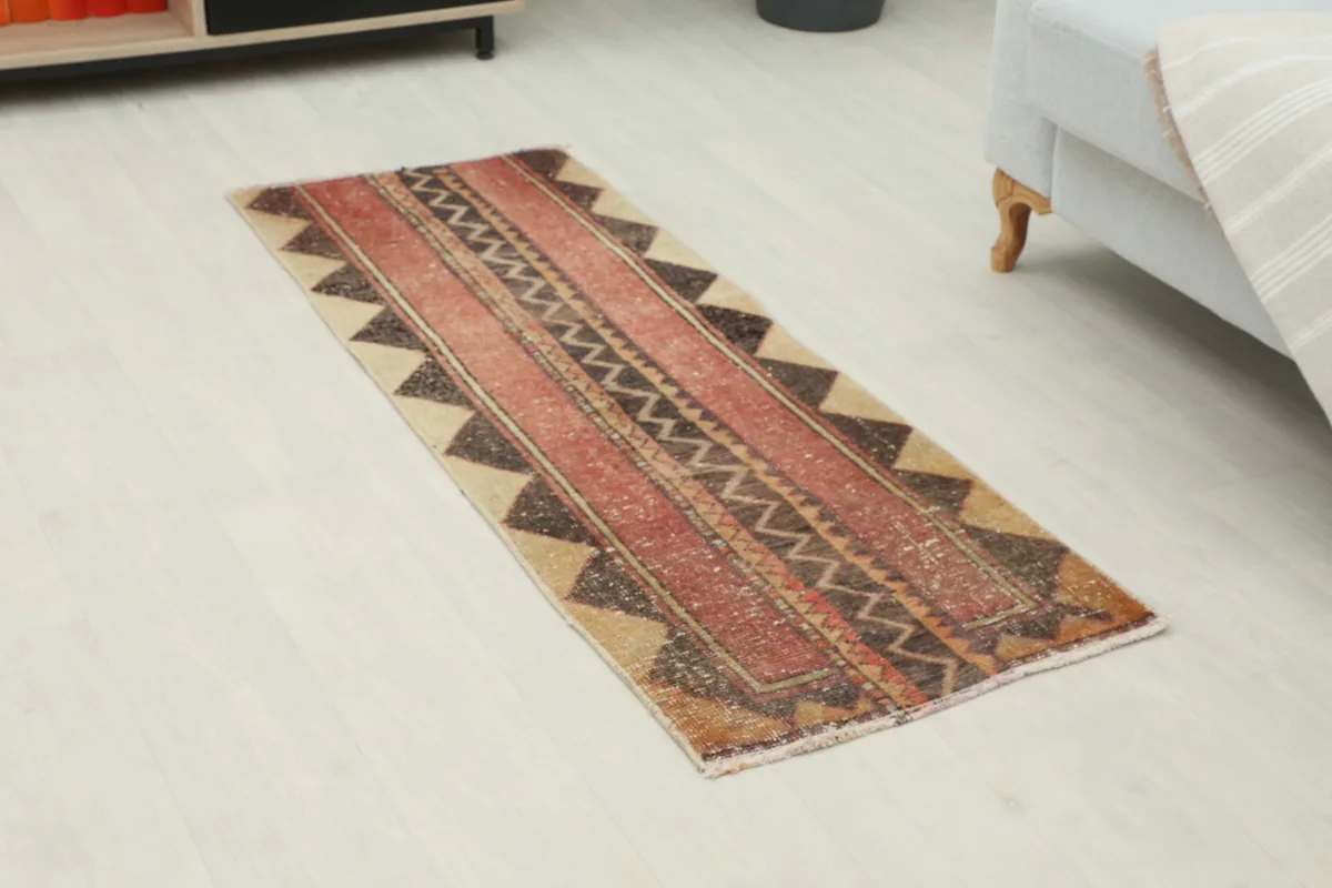 Overhead view of the runner rug, highlighting its red field and geometric patterns.