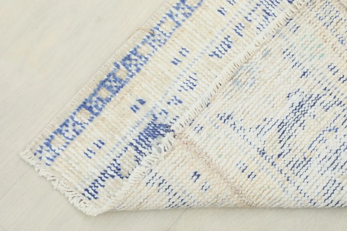 Corner of the runner folded back, revealing the cotton foundation and hand-knotted backing