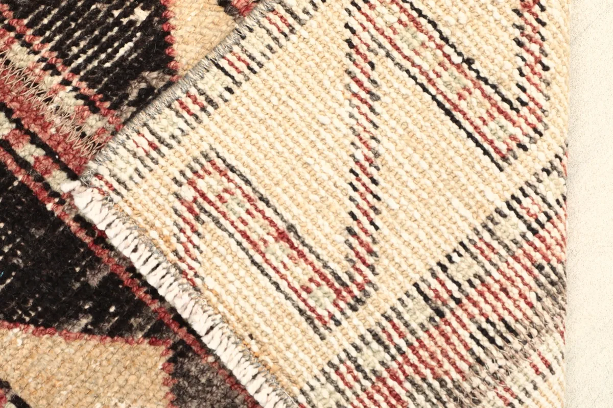 View of the rug's reverse side, revealing the cotton foundation and fine hand-knotting craftsmanship.