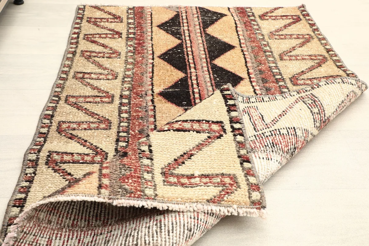 The rug folded to show its flexibility and the texture of both the front and back sides.