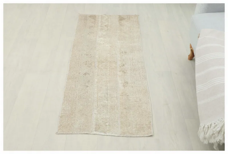 Full top view of the 1'10" x 4'7" tan and beige vintage Anatolian runner rug on a light floor.