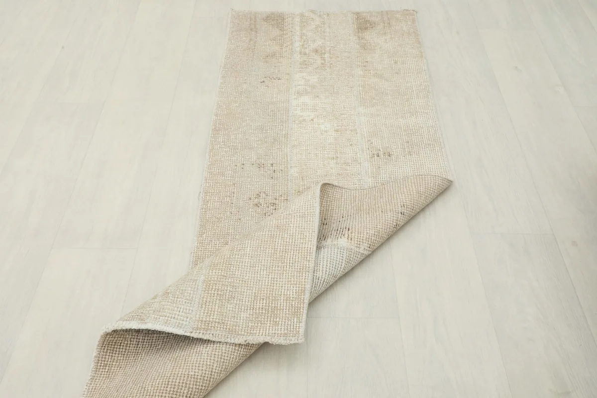 Runner rug with one end folded back, illustrating its flexibility and material thickness.