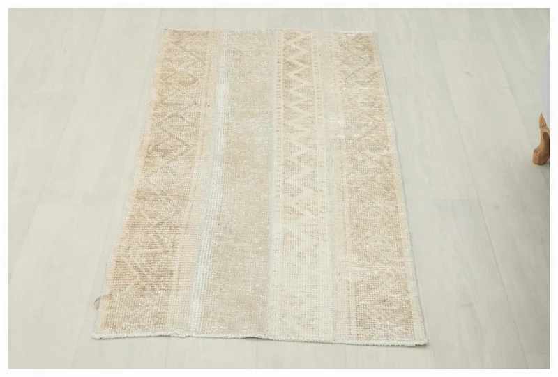 Full overhead view of the beige and cream vintage Anatolian rug on a white background