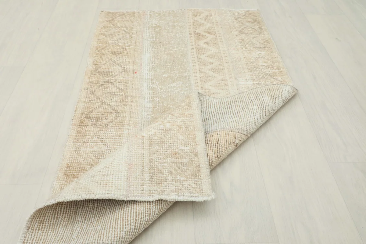 The vintage rug partially folded, showing its flexibility and construction