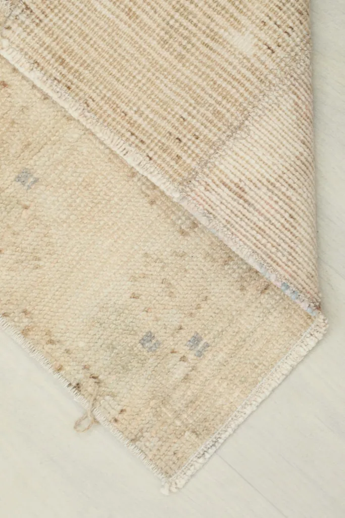 Corner of the runner folded to show the cotton foundation and the reverse side of the knotting.
