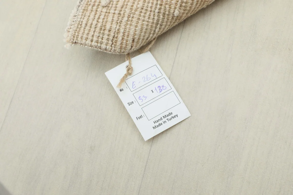 Tag attached to the rug, indicating it is hand-made in Turkey.