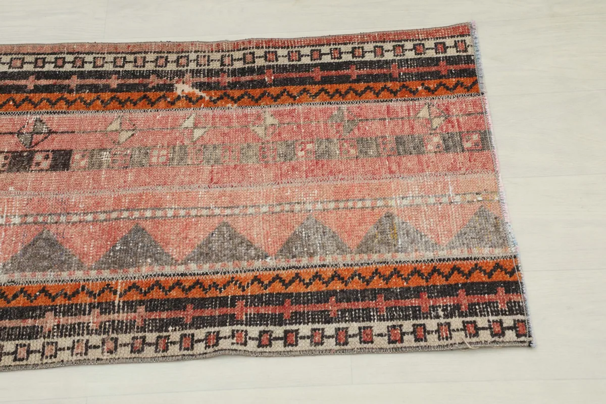 Close-up of the rug's surface showing geometric motifs and color variations on one end