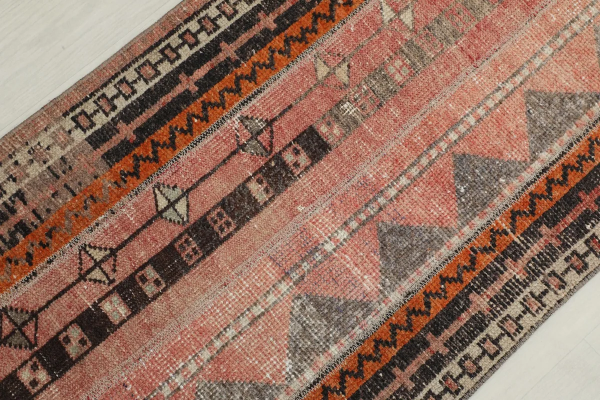 Detailed view of the rug's wool pile and intricate tribal patterns