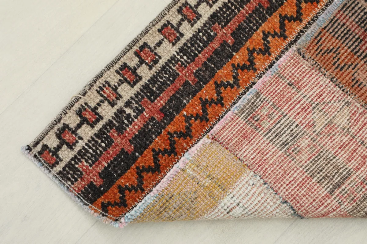 Partial view of the rug's back, revealing the cotton foundation and hand-knotted construction