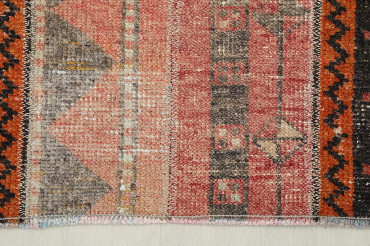 Close-up showing the short fringe and edge finishing of the vintage rug