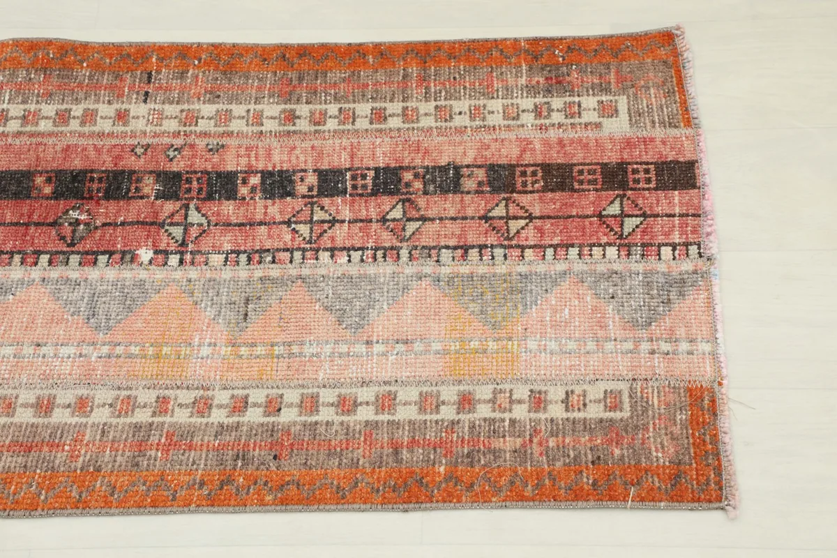 Close-up detail of the rug's patterns and colors at one end.