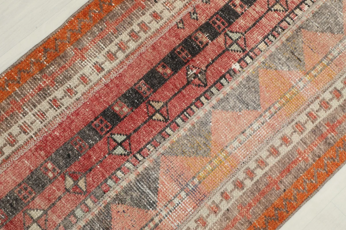 Diagonal close-up showing the varied geometric motifs and color transitions in the rug.