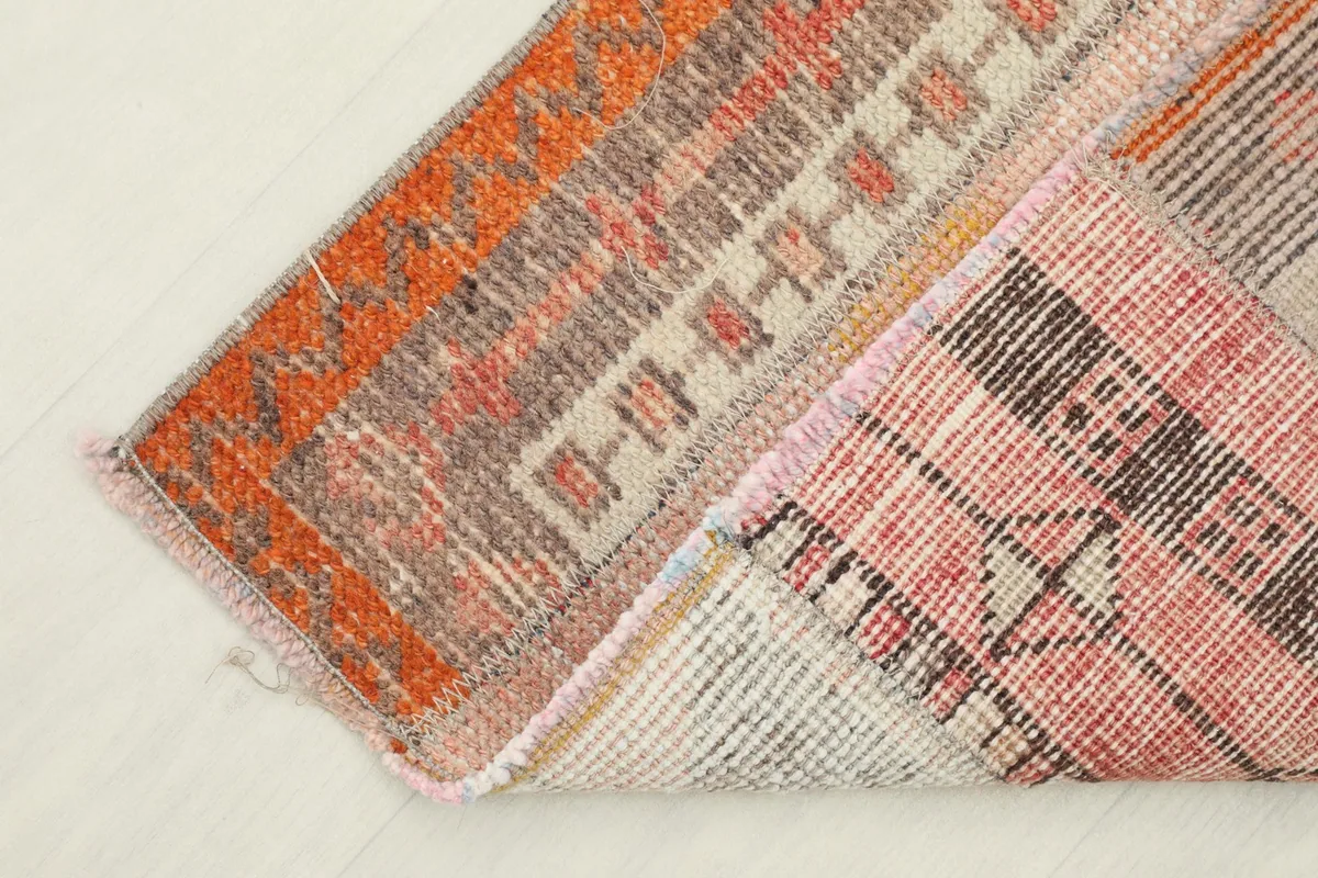 View of the rug folded back to show the reverse side and construction.