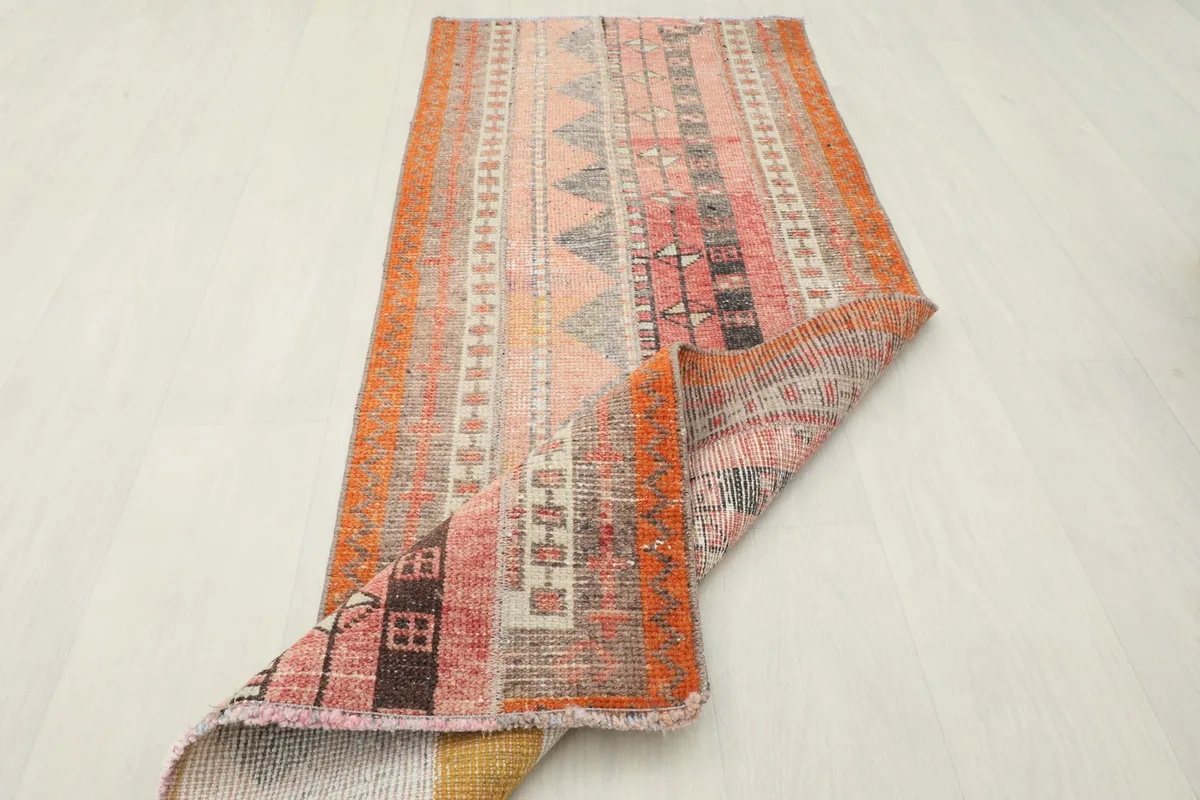 Angled view of the rug partially folded, showcasing the back and pile.