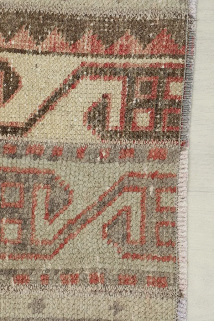 Close-up of the rug's edge, revealing the hand-knotted construction and varied colors