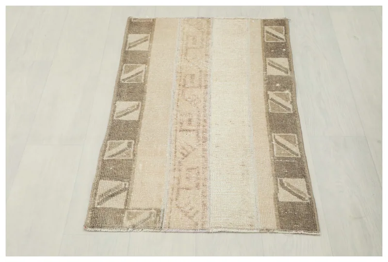 Full top view of a beige and brown striped vintage Anatolian rug on a white background.