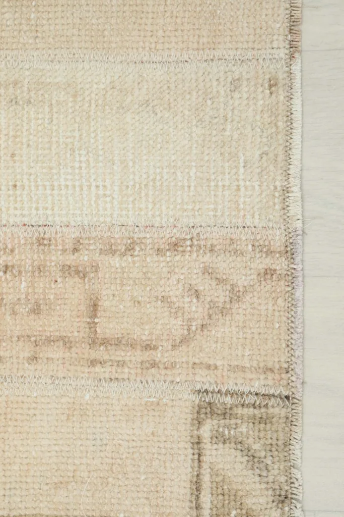 Close-up of the rug's side edge, displaying the tightly woven cotton foundation.