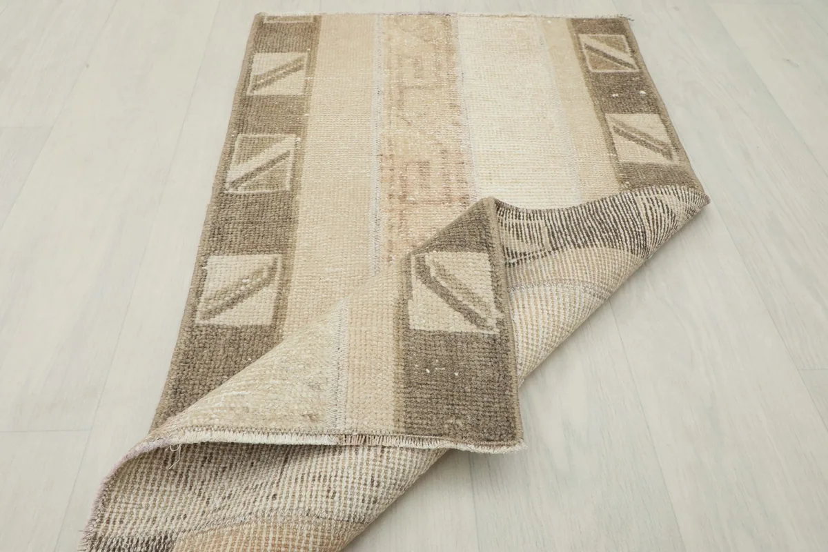 The rug partially folded, showing its flexibility and the underside construction.