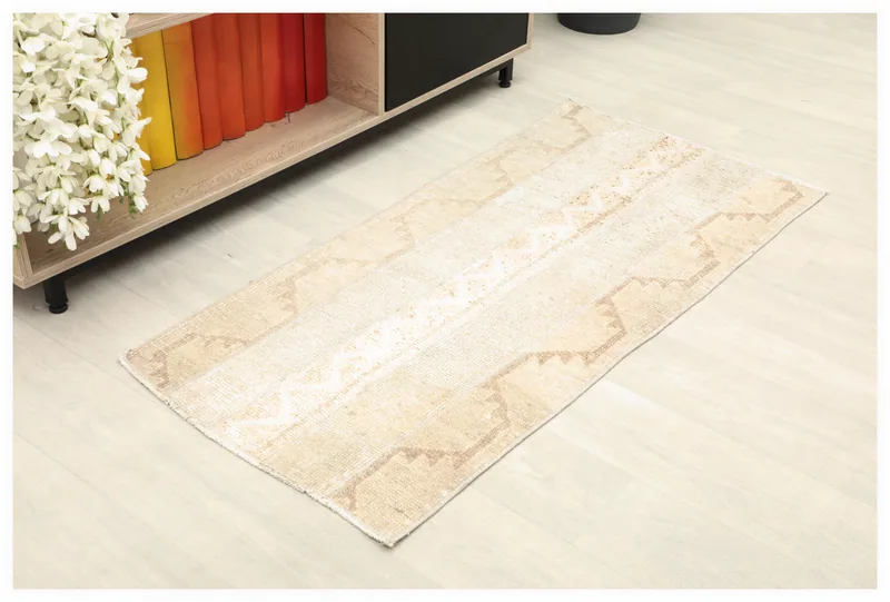 Full top view of the beige and tan vintage Anatolian rug on a light floor.