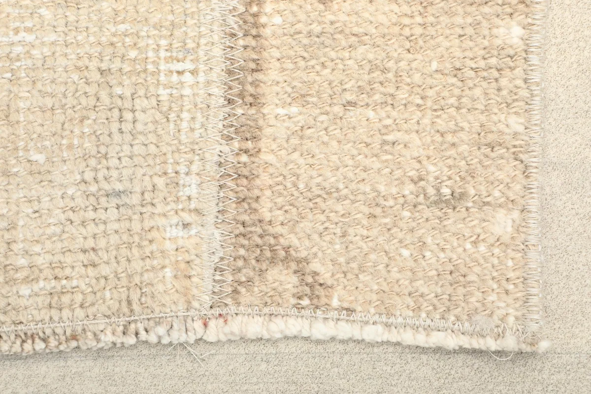 Close-up view of the hand-knotted wool pile texture and muted colors.