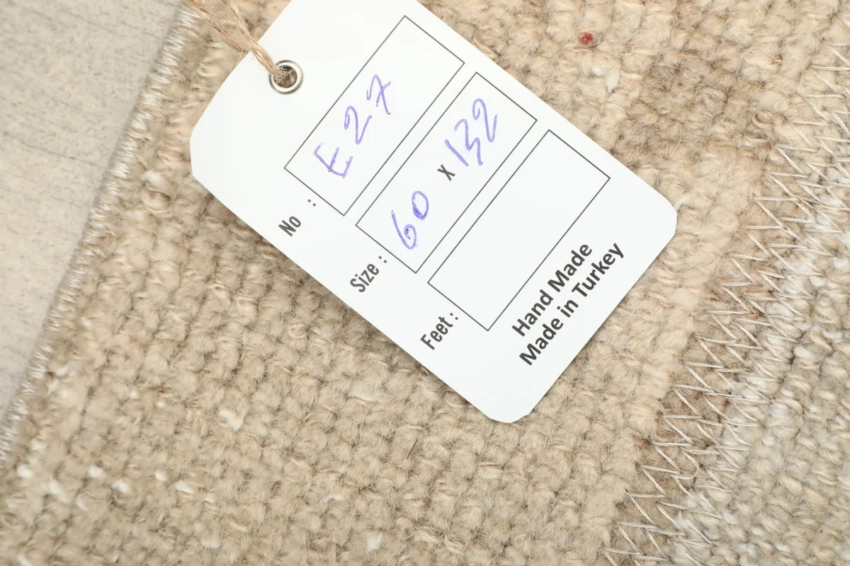 Close-up of the product tag, confirming the rug's hand-made origin and size.