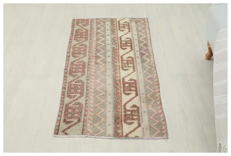 Full overhead view of the beige and rose striped tribal runner on a white background.
