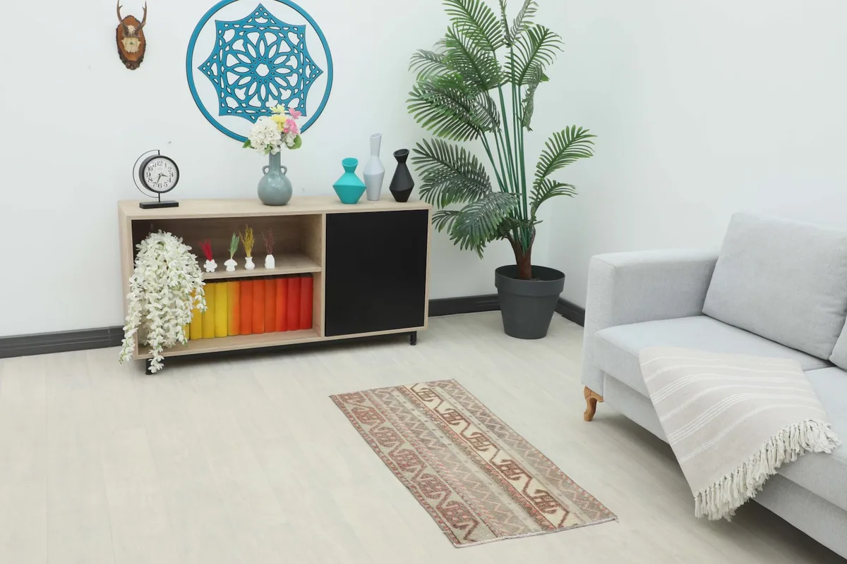 Runner rug placed in a living room setting next to a sofa and cabinet, showing its scale.