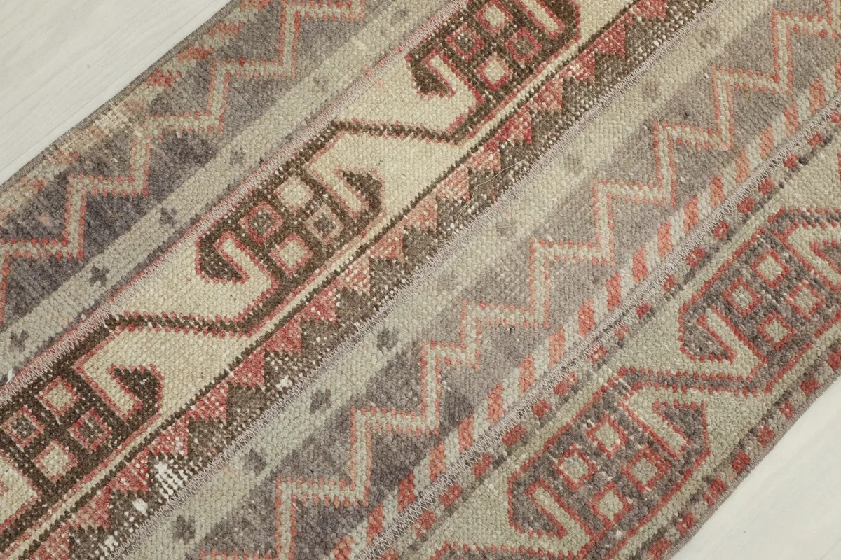 Angled close-up showing the low pile texture and intricate hand-knotted details of the rug.
