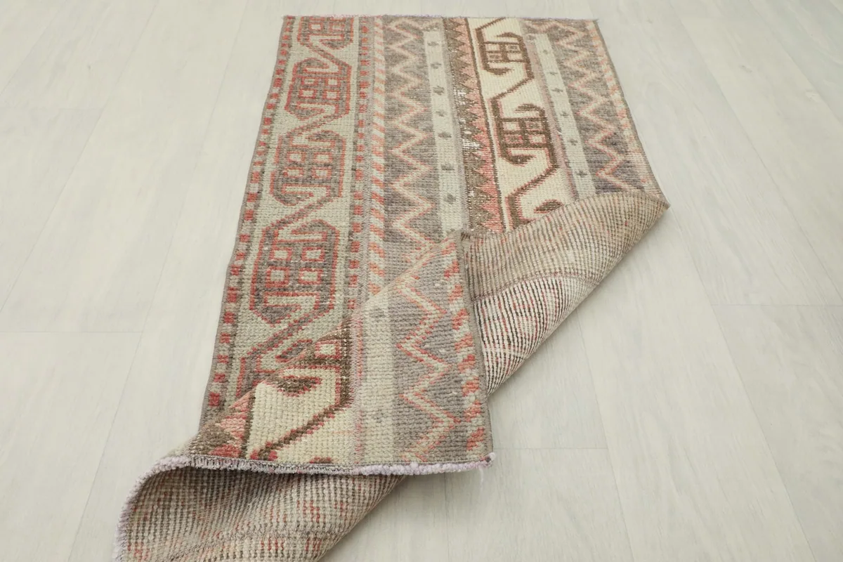 Runner rug partially folded, showing the flexibility and thickness of the vintage piece.