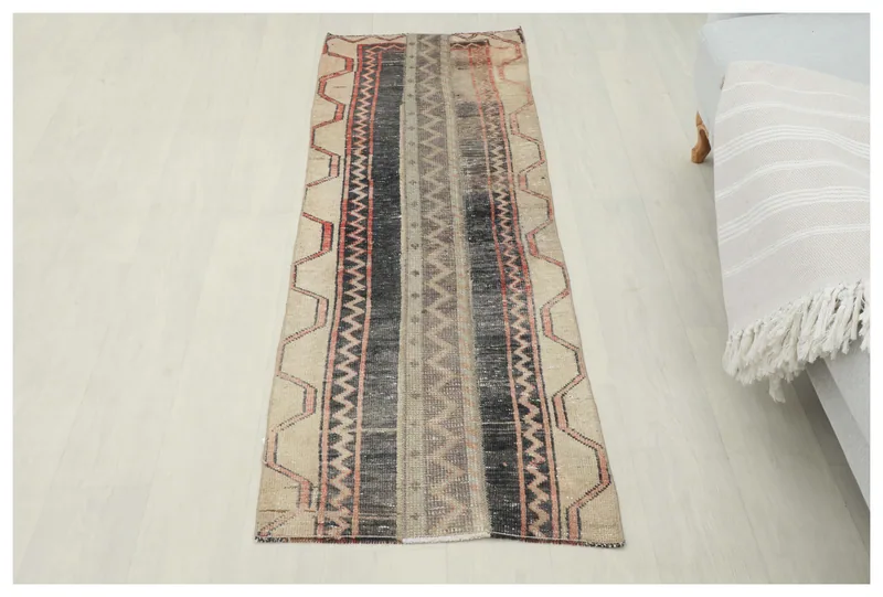 Full top view of the vintage tan and black geometric runner rug on a white background.