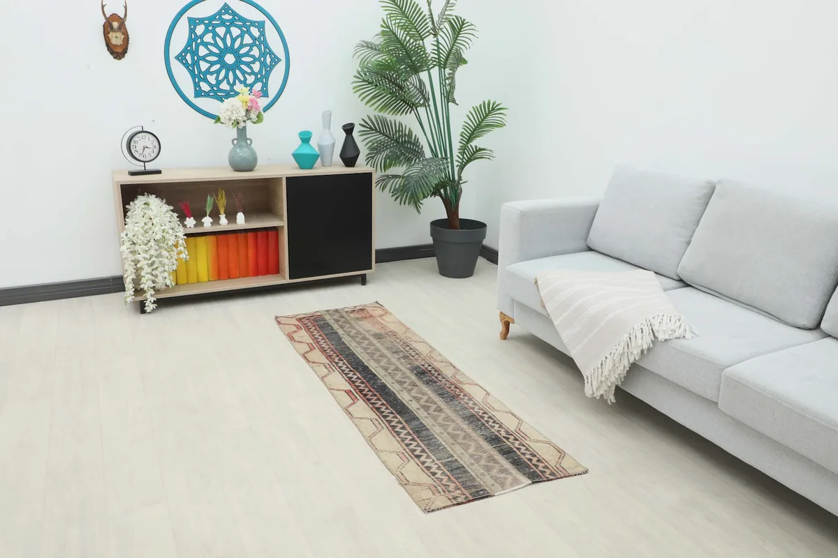 Runner rug placed in a living room setting next to a sofa and cabinet, showing scale.
