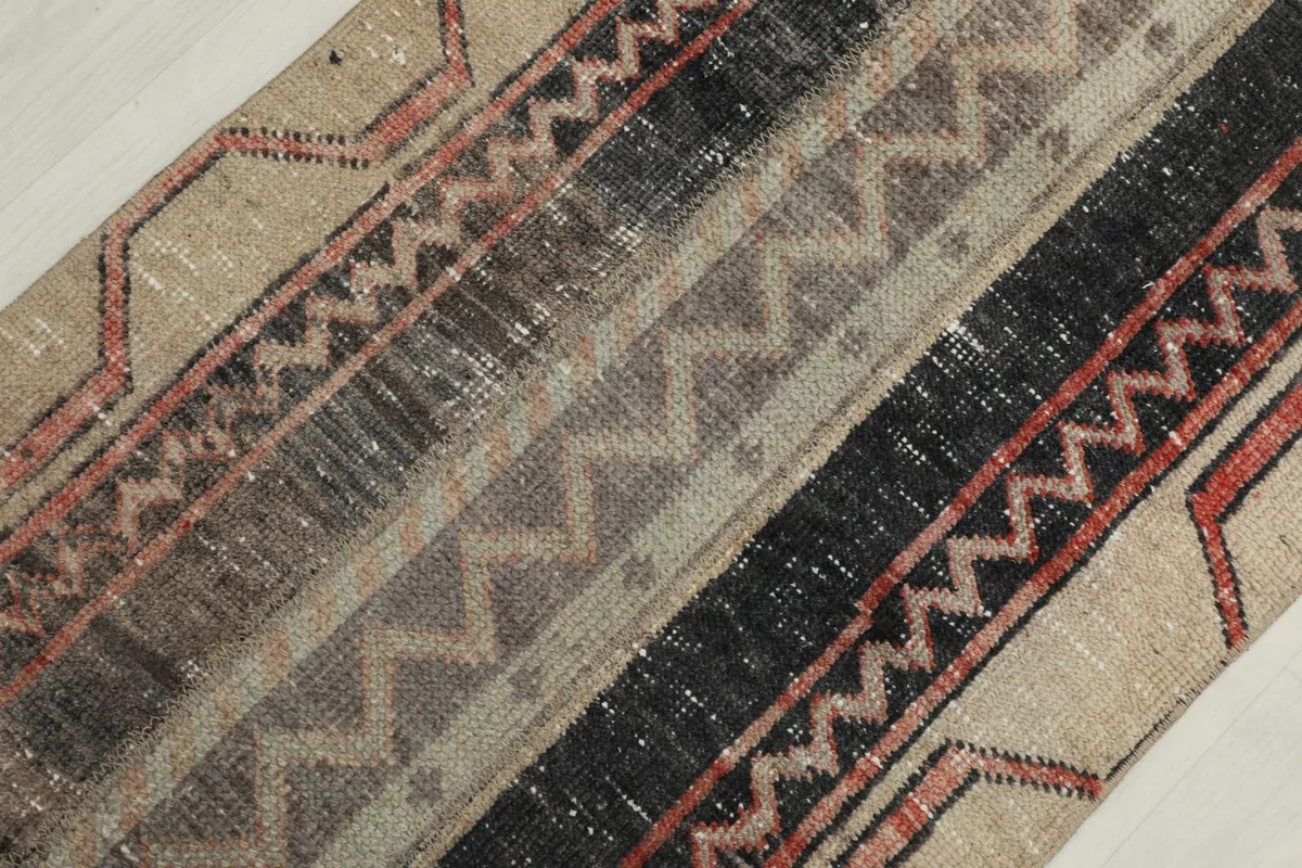 Detailed view of the central striped and geometric patterns in tan, black, and gray.