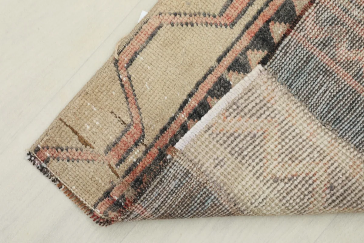 View of the back of the rug, showing the cotton foundation and knotting structure.